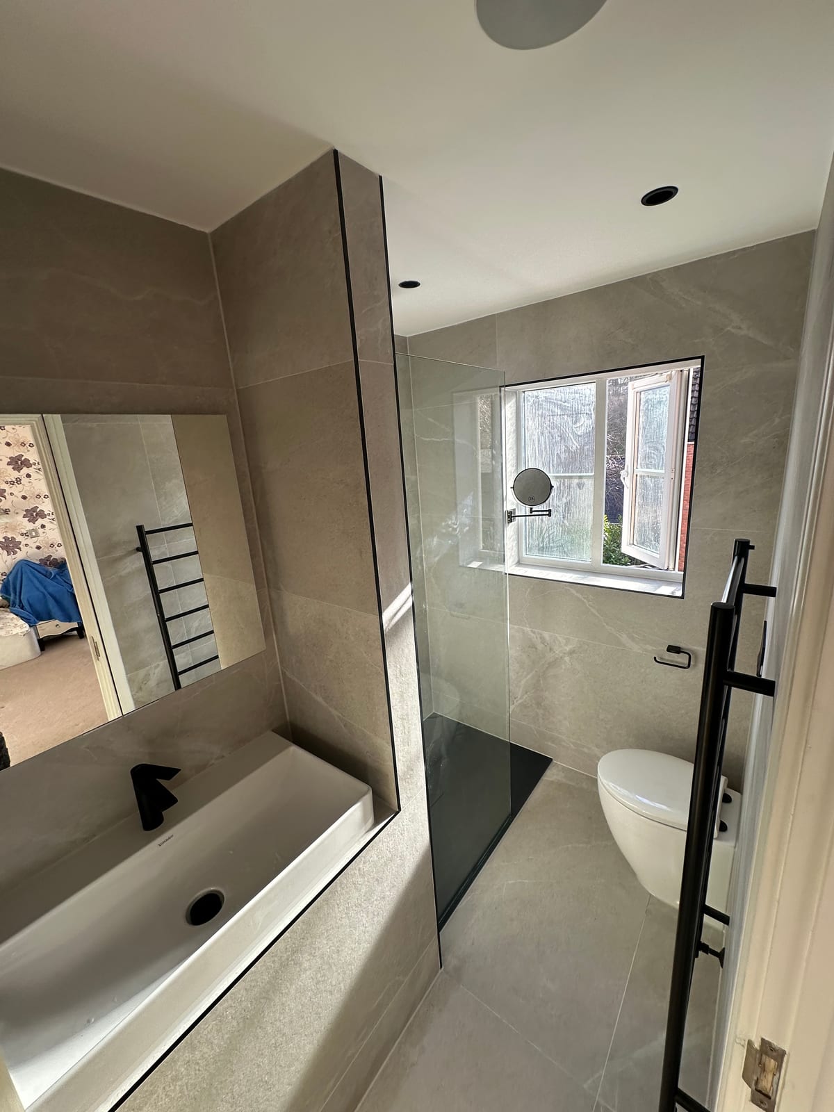 Contemporary bathroom with grey stone tiles and matte black fittings