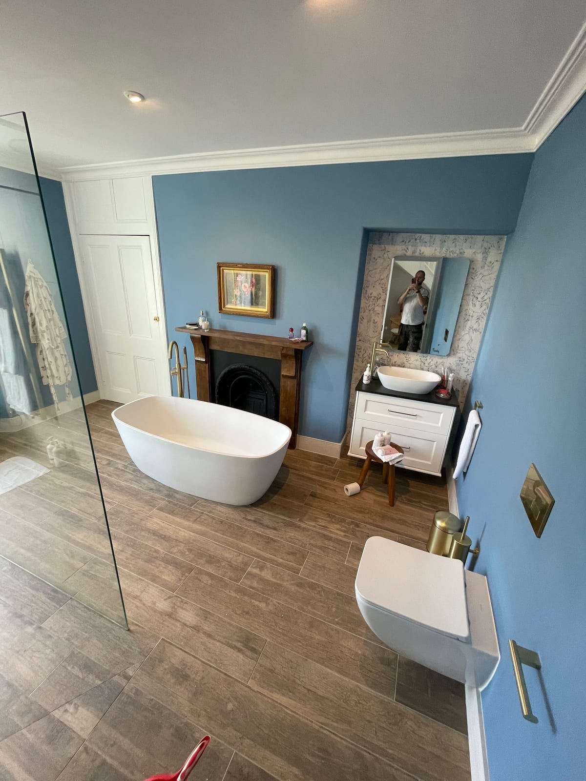 Blue bathroom suite with freestanding bath, vanity and fireplace